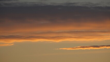 Fototapeta premium Serene Sunset Sky Layers of Golden and Gray Clouds