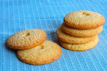 Butter cookies biscuits pile on blue kitchen cloth close up photo. Breakfast or dessert bakery product. Homemade pastry. Food background design template with copy space