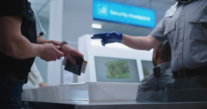 Airport Security Checkpoint during Boarding Flight. Diverse Passengers Put Personal Belongings in Plastic Trays for Scanning: Tablet Computer, Phone, Documents. Security Officers Control Procedures.