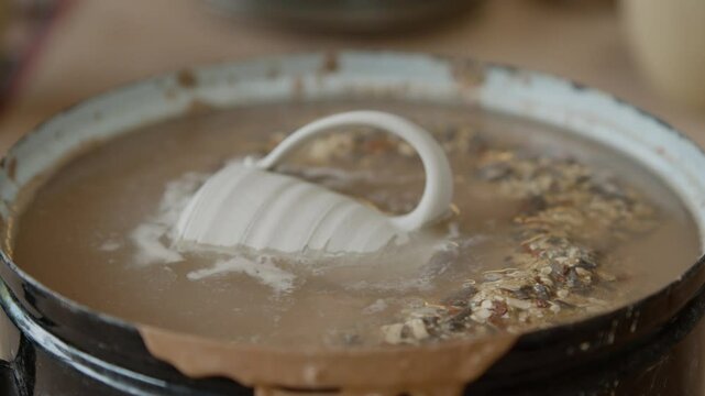 Destruction of poorly made pottery in water, recovery of clay for reprocessing