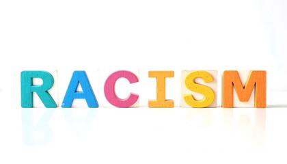Fototapeta premium Colorful wooden blocks spelling 'racism' on a white background convey a serious message with a contrast of playful colors.