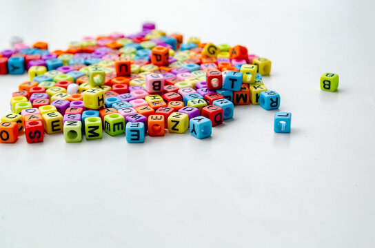 Colorful plastic alphabet beads with letters printed on them - Powered by Adobe