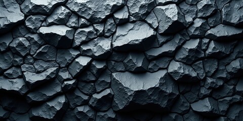 A dark gray rock wall adorned with intricate cracks and crevices. Its rugged, textured surface reveals a natural mosaic of patterns