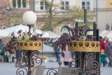
a beautiful bouquet of flowers placed on the street in a metal vase.