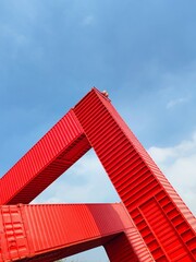 Red cargo container on blue sky background. Industrial and logistics concept.