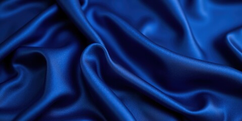 Fototapeta premium Deep royal blue satin glistens with smooth texture; its folds create dynamic movement and captivating depth in this close-up view