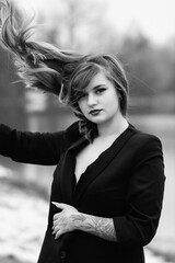 Portrait of a young beautiful blonde girl outdoors. Black and white photo.