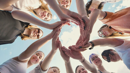 Students forming a circle with their hands, representing unity, teamwork, and the power of friendship