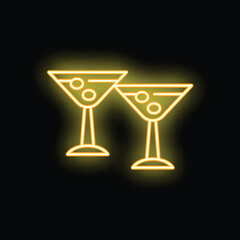 Neon yellow martini glasses with olives glowing on black background