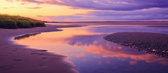 Sunset Over Coastal River Estuary with Reflective Water and Cloudy Sky