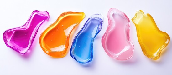 Fototapeta premium Colorful liquid detergent pods arranged on a white surface with ample copy space for text.
