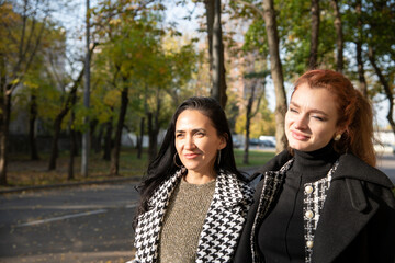 Women enjoy a sunny autumn day walking down a tree-lined street