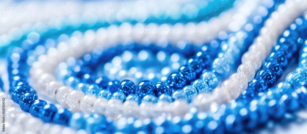 Poster blue and white glass beads arranged in a spiral pattern on a light background with copy space for te