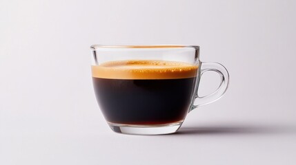 A small glass espresso cup with rich crema on top, sitting on a white background