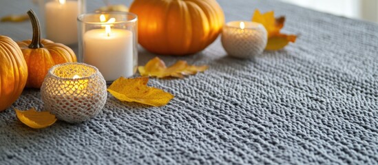 Autumn table setting with candles mini pumpkins and yellow leaves on a crocheted tablecloth perfect for festive celebrations and copyspace