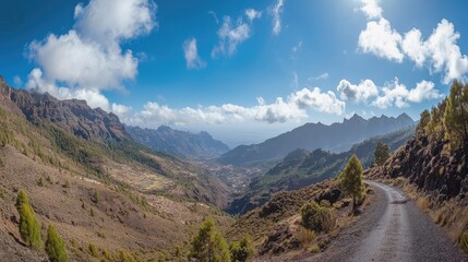 Naklejka premium Breathtaking panoramic landscape of a mountain pass surrounded by lush valleys and dramatic peaks under a clear blue sky