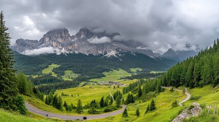 Naklejka premium Winding road amidst dramatic Alps scenery with lush greenery under a cloudy sky creating a stunning landscape view.