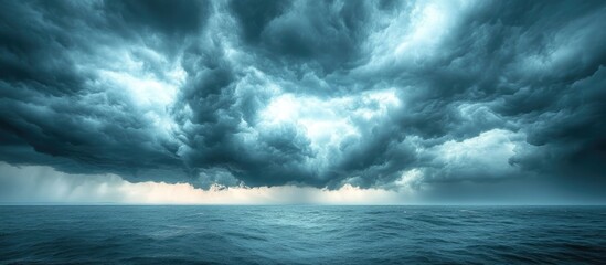 Dramatic cloudy sky over calm ocean sea with moody lighting and expansive view ideal for backgrounds Copy Space