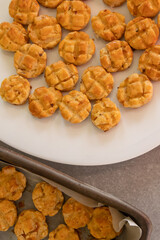 Homemade golden scones on a white plate and on a baking sheet.