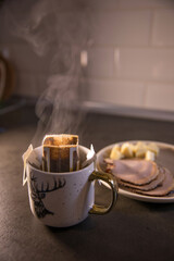 Cup of coffee in a drip bag on the table in the kitchen