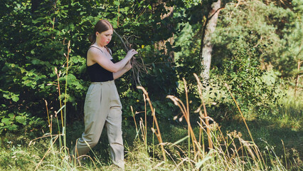 A young schoolgirl carrying branches for the fire.