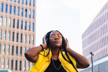 Stylish black woman relaxing listening music