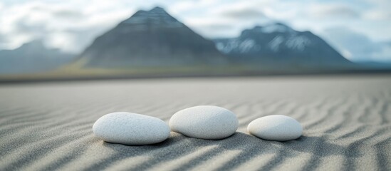 Stones on sandy beach with mountains in the background and soft focus Copy Space available for text placement