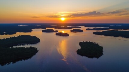 Obraz premium Sunset over the serene lake and islands, a breathtaking aerial view of nature's tranquility