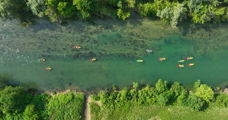 Wide overhead aerial of group kayaking on river in colorful Croatian landscape