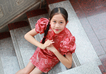 Closeup Chinese girl in traditional dress with greeting posture celebration for Chinese New Year.