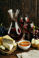 Red wine in a decanter and different types of cheese