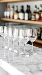 Empty wine glasses on a marble bar, liquor bottles blurred in background.