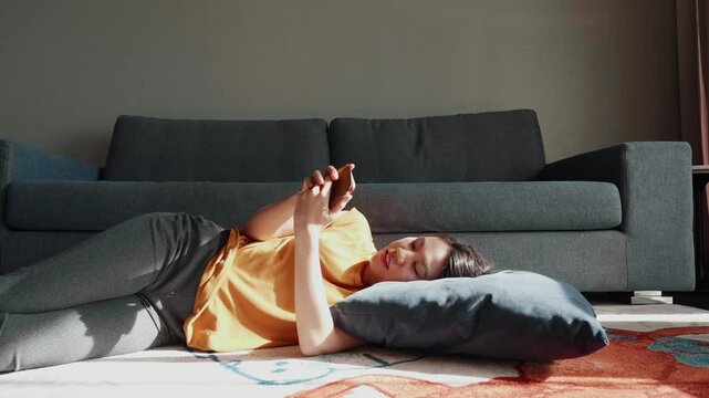 A serene indoor scene featuring a person lounging on the floor with a pillow, enjoying a moment of relaxation near a comfortable couch. The warm ambiance highlights the cozy atmosphere.