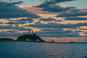 Obraz premium sunset over the sea with ships and lighthouse