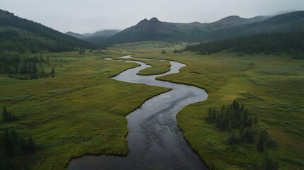 River meanders through green valley, misty mountains