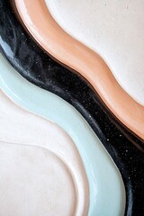 Obraz premium Vibrant swirls in teal, peach, and black flow across a neutral surface, showcasing a stylish pattern that blends retro influences with contemporary design