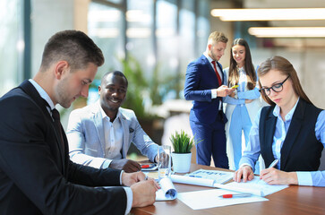 Business team discussing together business plans in office.