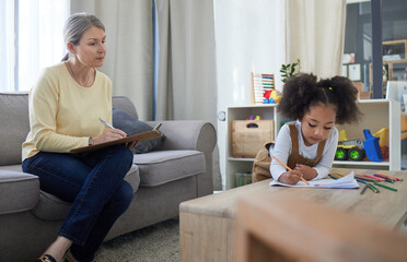 Art therapy, psychologist and counseling with kid in office for trauma processing, child...