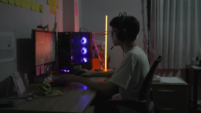 Young Gamer Engrossed in Online Gameplay at Night