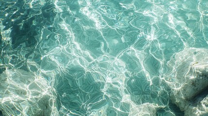 Obraz premium Abstract Teal Water Texture: Sunlit Ripples and Submerged Stones
