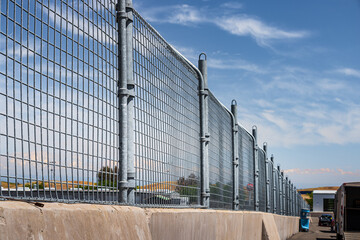 Obraz premium Long Mesh Fence with Clouds