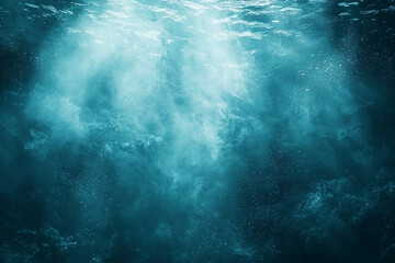 Fototapeta premium Submerged view: sunlit ocean depths, particles suspended, rocky seabed.