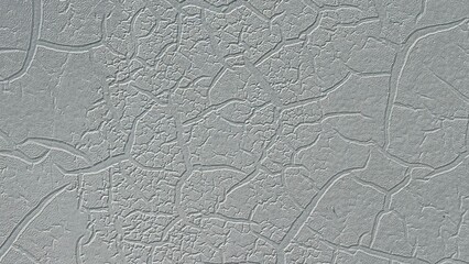 Cracked Plaster Texture: A detailed close-up reveals the intricate network of cracks in a light...