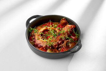 A close-up of a grilled octopus dish, showcasing the tender texture of the octopus and the contrast with the crispy vegetables