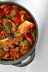 A close-up of a grilled octopus dish, showcasing the tender texture of the octopus and the contrast with the crispy vegetables