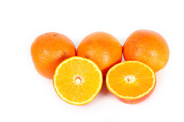 Several whole oranges and halved oranges arranged on a white background