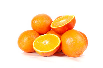 Several whole oranges and halved oranges arranged on a white background