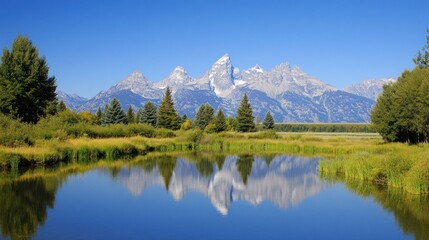 Majestic mountain range reflected in a calm lake, surrounded by lush greenery under a clear blue sky.