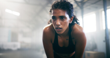 Fitness, thinking and tired woman resting in gym for intense workout, fatigue or exercise recovery. Break, sweating and athlete breathe to relax in sports club for wellness, body health or training