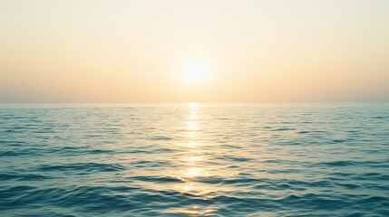Obraz premium The sun sets over a tranquil ocean, painting the sky in hues of gold and peach, reflecting softly on the water's surface.
